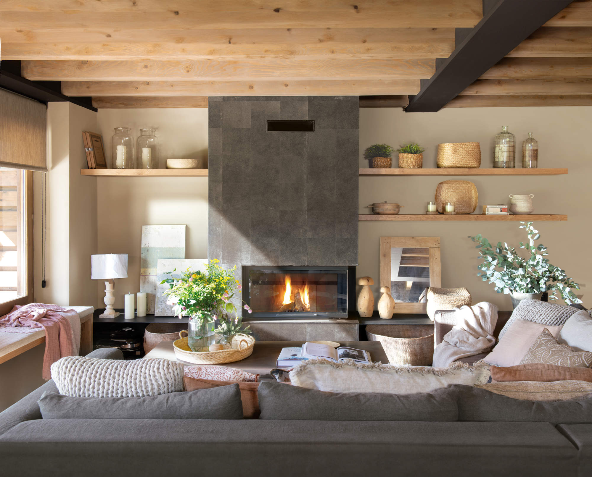 Salón cálido y rústico moderno con chimenea y librería